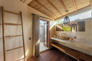 Relax in a serene bathroom with a sink, large mirror, and wooden ladder.