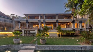 A resort with a pool, outdoor seating, and a well-lit entrance.