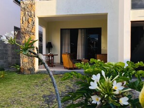 Relax in a serene outdoor space surrounded by lush greenery and a beautifully manicured lawn.