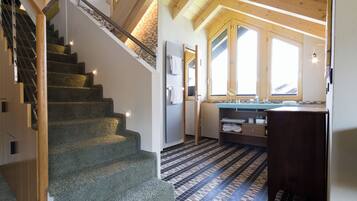 A staircase leading to a second floor with a wooden interior and a tiled floor.
