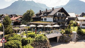 Un restaurant offrant une vue sur la montagne, avec une terrasse et un chemin de pierre menant à l’entrée.