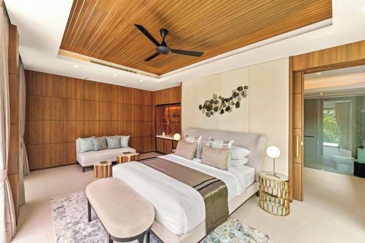 Quarto moderno com uma cama grande, ventilador de teto e vista para uma varanda.