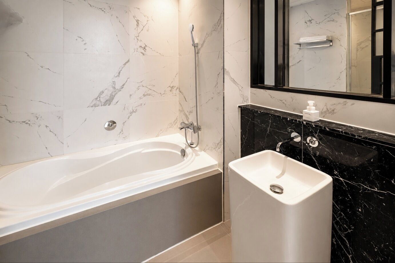 Une salle de bain moderne avec une baignoire, un lavabo et un miroir.