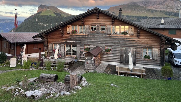 A wooden chalet with a balcony, a flag, and a mountain view. - Charming log chalet at 1200 m – CAR-FREE, access by gondola only (Emmetten)