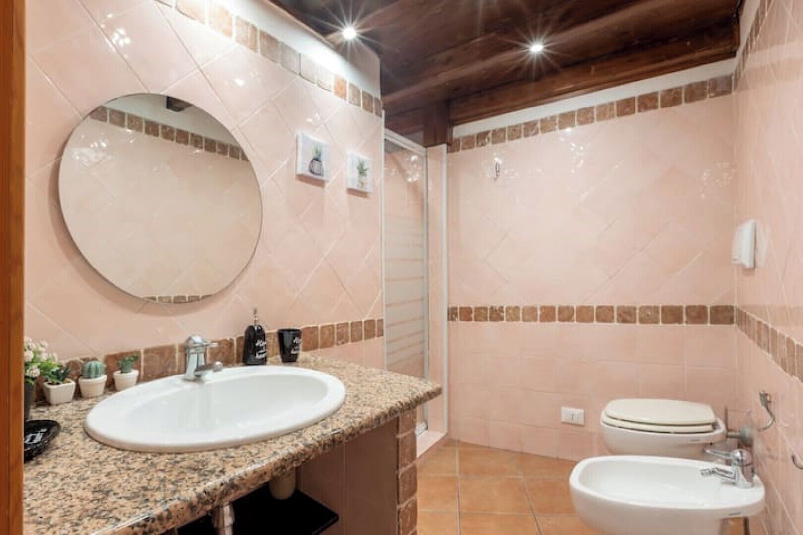 A bathroom with two sinks, a mirror, and a toilet.