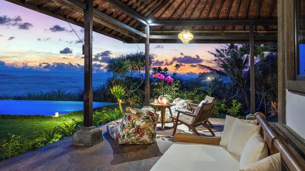 A covered outdoor seating area with a view of the ocean at sunset. - Bali Amori Vista (Cemagi)