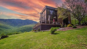 A modern house with a glass facade, situated on a hillside with a view of mountains. - The Redstone Estate - Luxury Mountain Venue for Weddings/Events/Large groups (Burnsville)