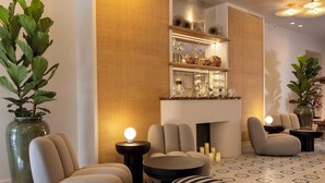 A modern lounge area with comfortable seating, a fireplace, and decorative shelves. - Le Clark Hotel (Paris)
