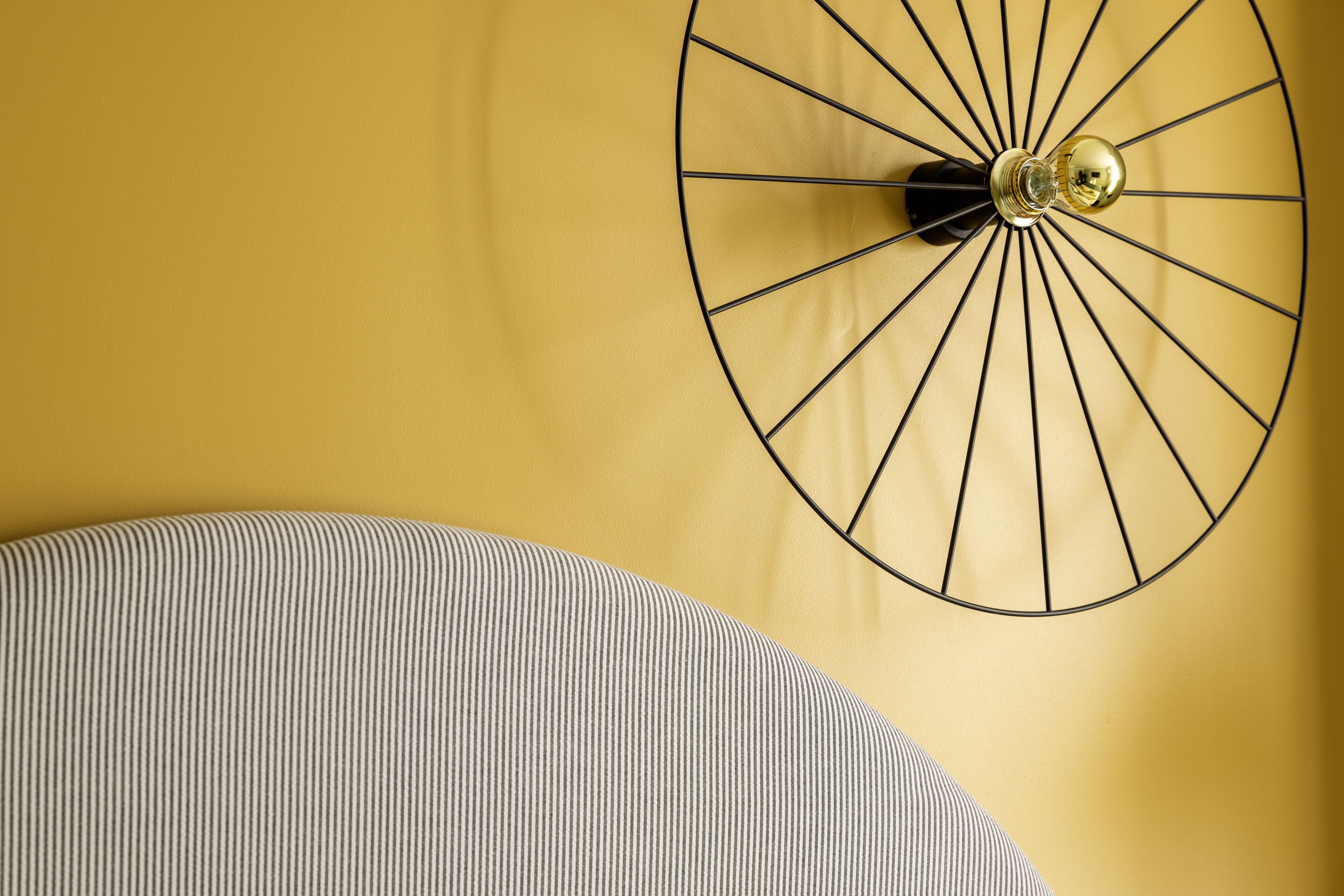 A wall-mounted clock with a circular design and a single hand.