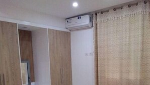 Un dormitorio con una cama, armario de madera y aire acondicionado.