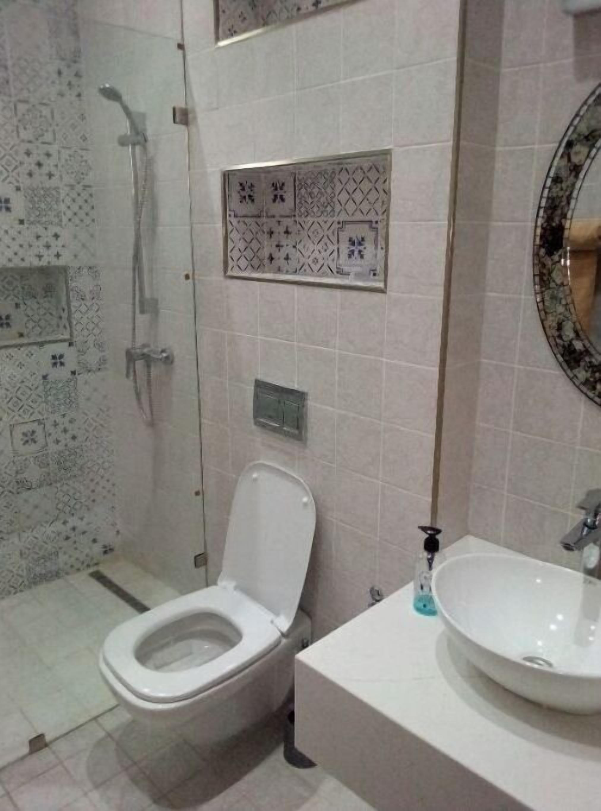Une salle de bain avec des toilettes, un lavabo et une douche.
