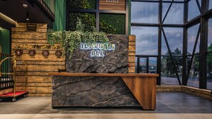 A reception desk with a stone facade and a sign that reads "AKHALTSING W". - Akhaltsikhe Inn (Akhaltsikhe)