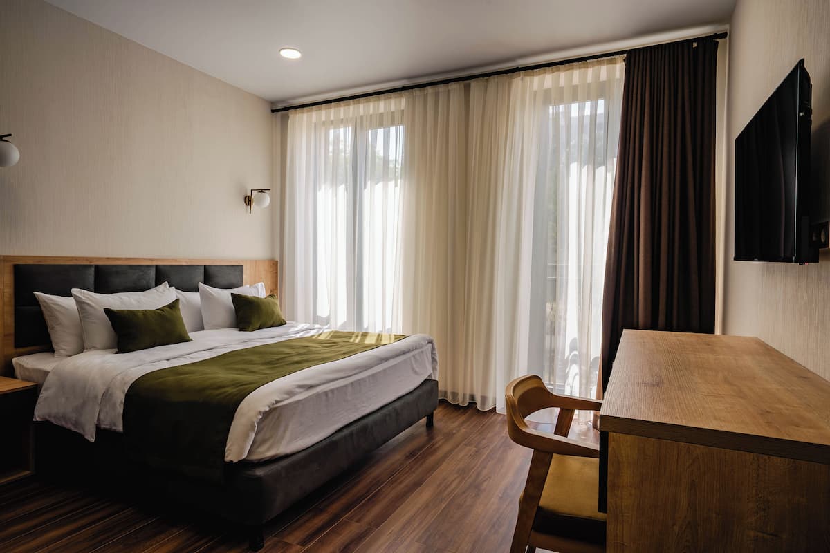 Una habitación de hotel con cama, escritorio y televisión.