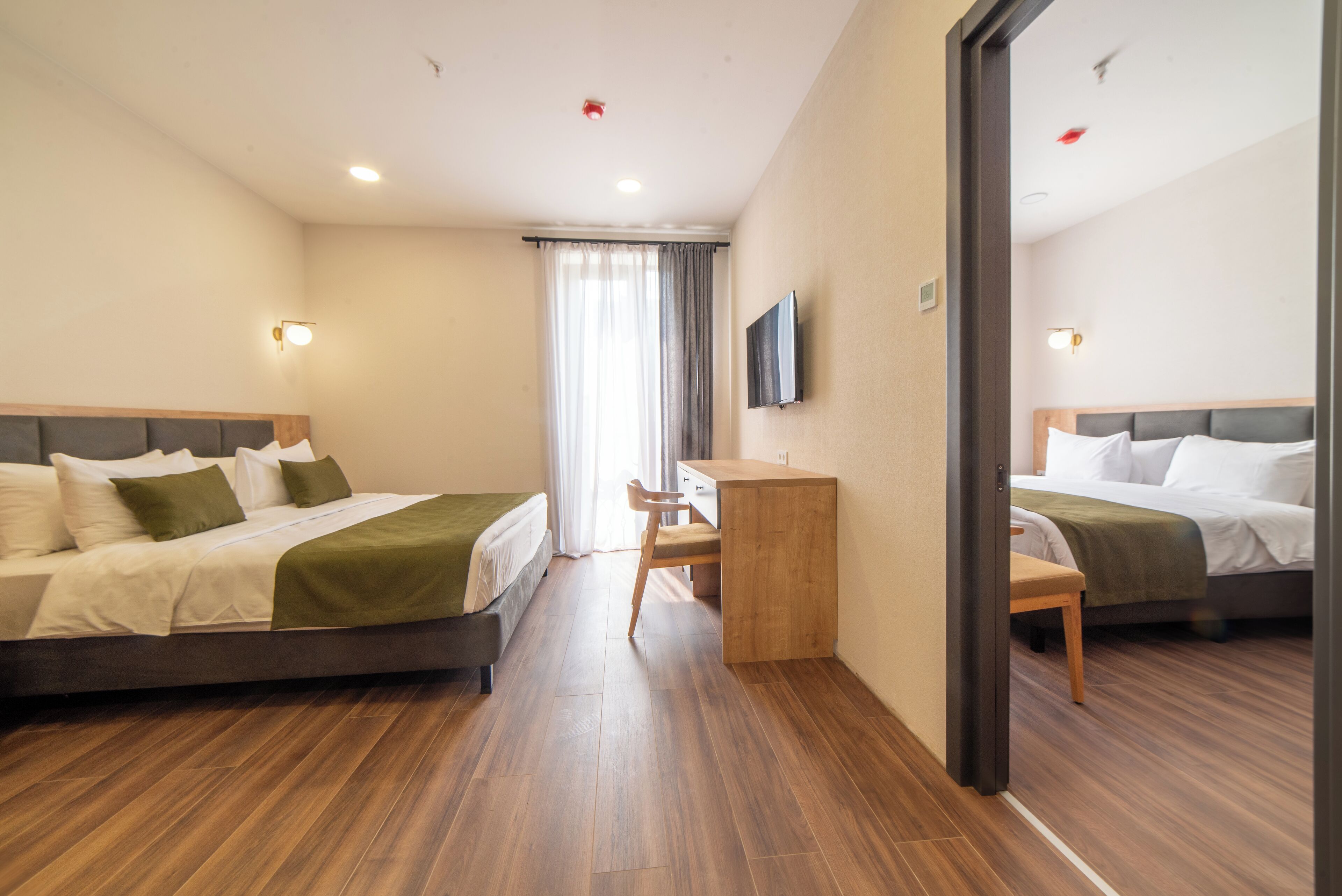 Een hotelkamer met twee bedden, een bureau en een stoel.