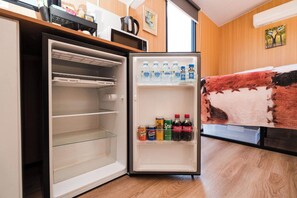 An open refrigerator with shelves stocked with beverages and a freezer compartment. - Hermano Farm Stay by Tiny Away (Turill)