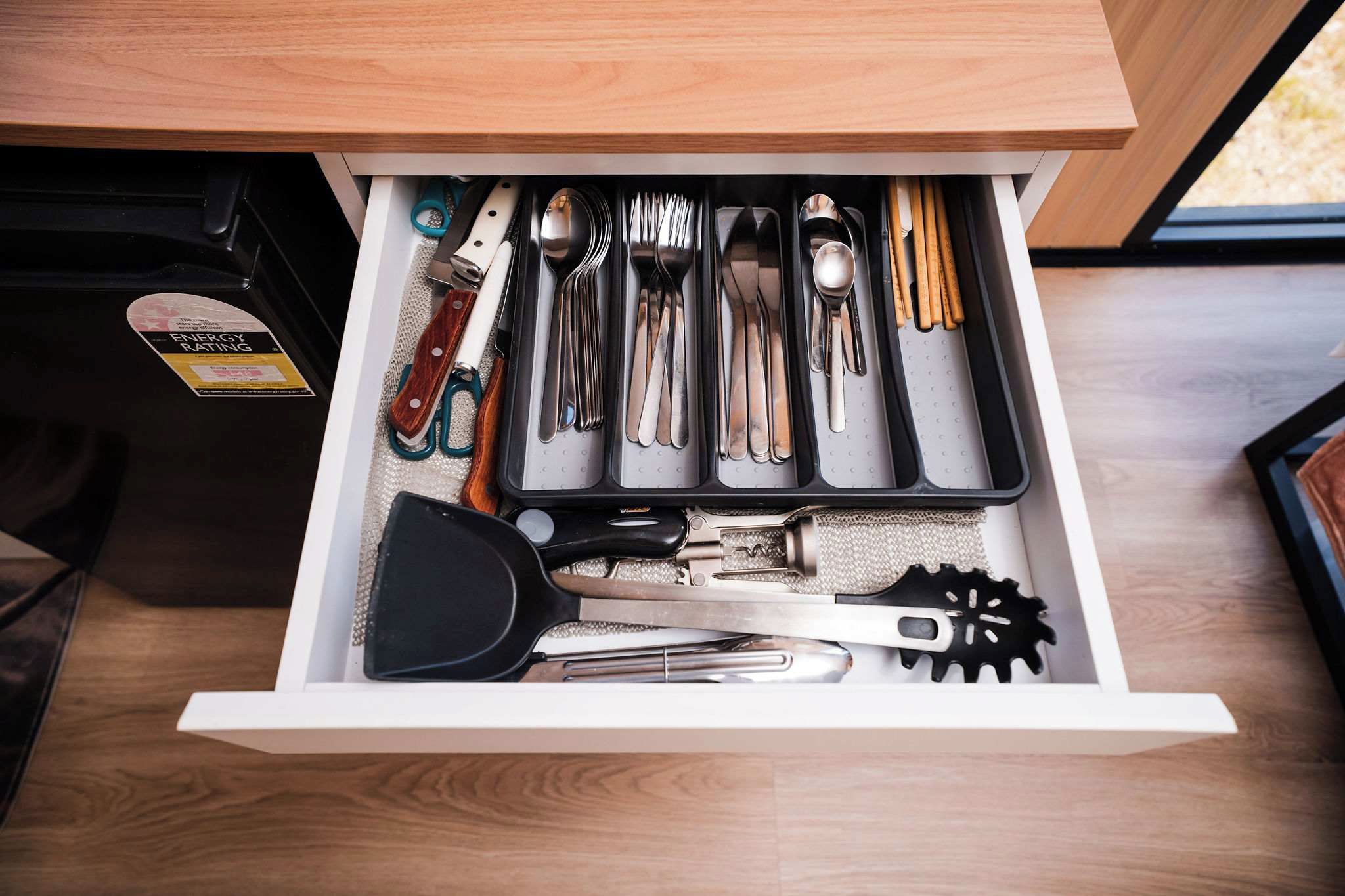 A drawer with various kitchen utensils neatly organized.