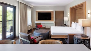 Habitación de hotel con cama, televisión, escritorio, silla y ventana.