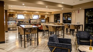 Un restaurante moderno con zona de bar, diversas opciones de asientos, incluyendo taburetes y sillas, y un menú visible.
