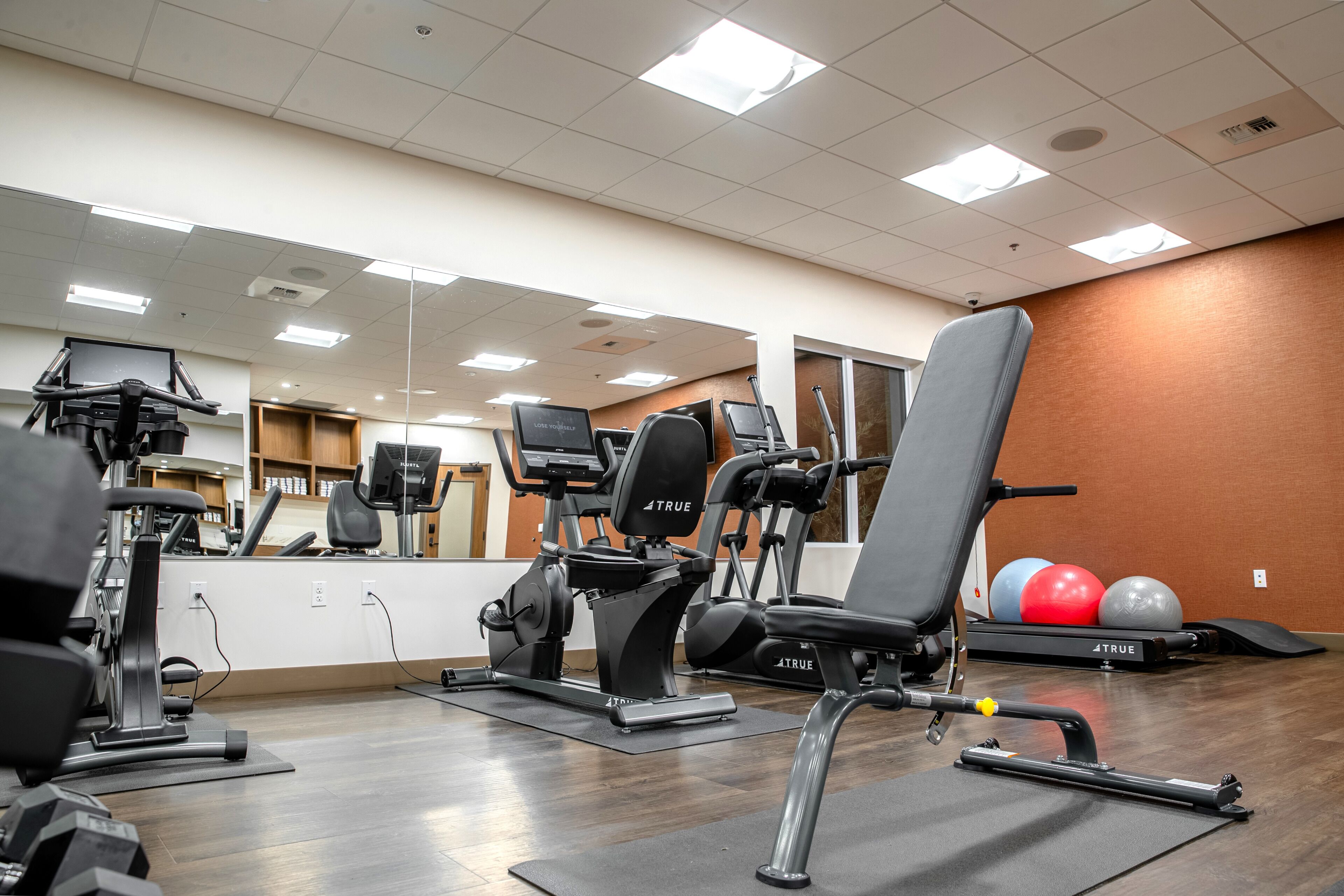A gym with various exercise equipment, including treadmills, weight machines, and free weights.