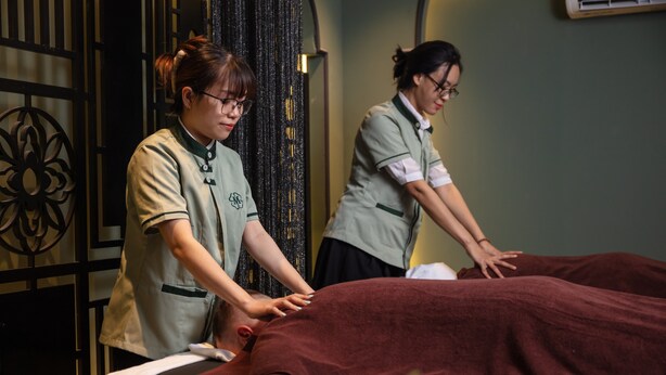A massage therapy session in a room with a patterned wall and a decorative metal gate. - Madelise Adora Hotel (Hanoi)