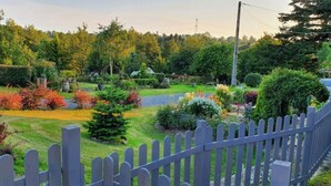 A well-maintained garden with various shrubs and trees, a neatly trimmed hedge, and a wooden fence. - Gîte Charmant à la Campagne (Chérencé-le-Héron)