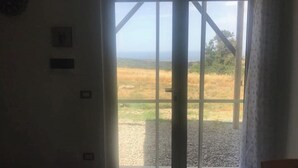 A room with a large sliding glass door leading to a grassy outdoor area. - Loft relaxation in the hills (Lazio)