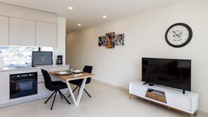 A modern kitchen with a dining area, a flat-screen TV, and artwork on the wall. - A134 - Panoramic View of the Lagoon (Sint Maarten)