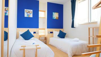 Habitación de hotel con dos camas, muebles de madera y obras de arte en las paredes.