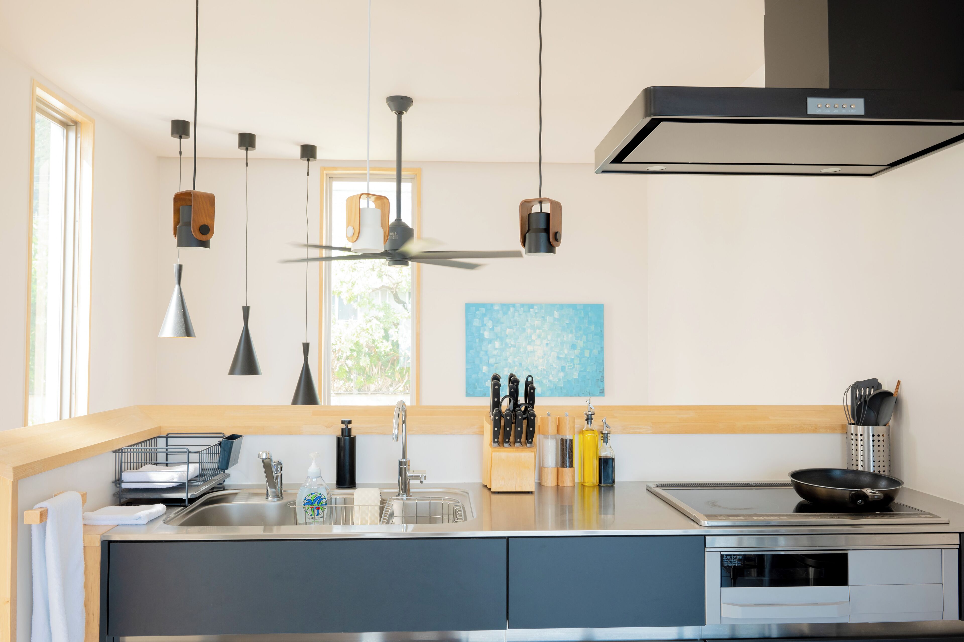 A modern kitchen with a built-in stove, a sink, and a window.