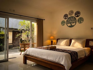 Une chambre à coucher avec un lit, une lampe et un mur décoré d’assiettes.