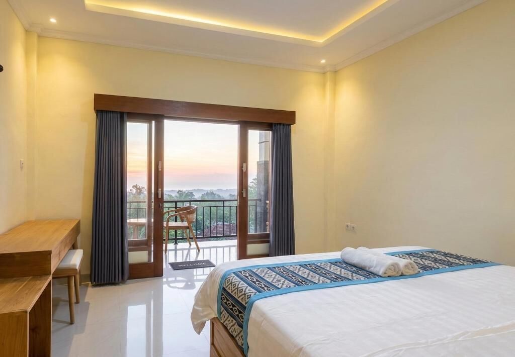 A hotel room with a bed, a desk, and a balcony with a view.