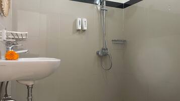 A bathroom with a sink, a shower, and a toilet.