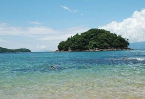 A clear view of a small island with lush greenery surrounded by calm blue waters. - Recanto Amorim - Caraguatatuba (Caraguatatuba)