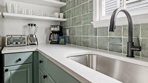 A kitchen with a stainless steel sink, a coffee maker, and a toaster on the counter.