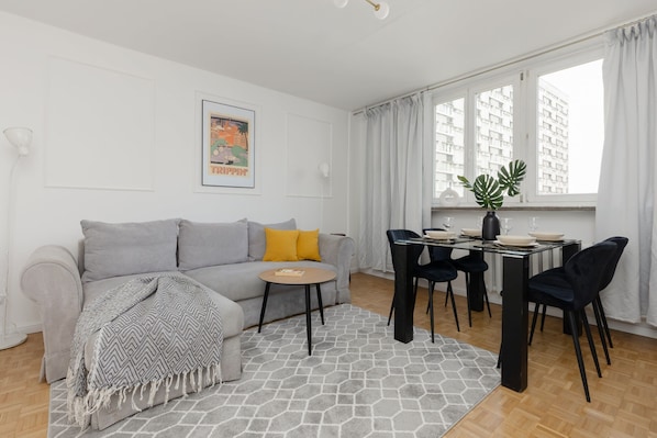 Relax in this stylish living space with a sofa, coffee table, and dining area.