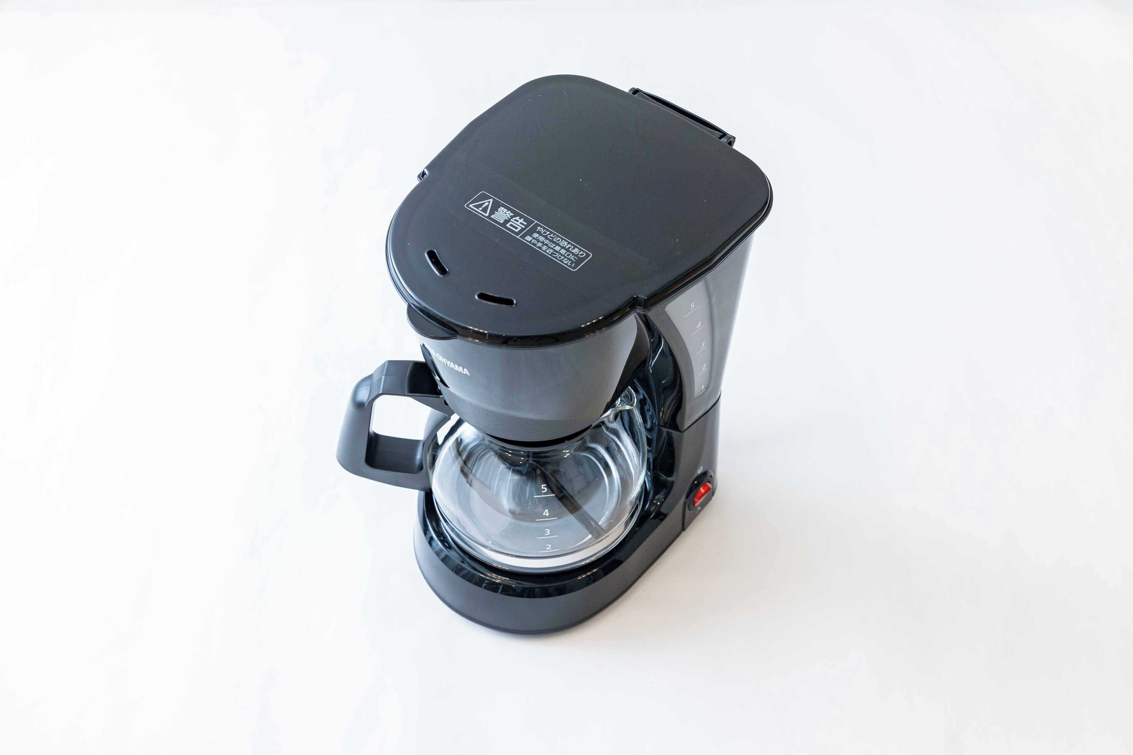 A black coffee maker with a clear water reservoir and a digital coffee strength indicator.