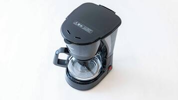 A black coffee maker with a clear water reservoir and a digital coffee strength indicator.
