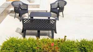 Un patio con mesa y sillas, con vistas a la costa.