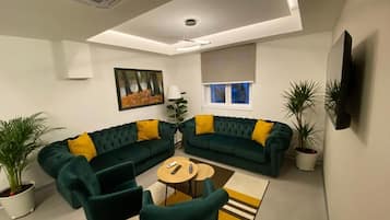Un salon moderne avec un canapé d’angle, une table basse et des plantes en pot.