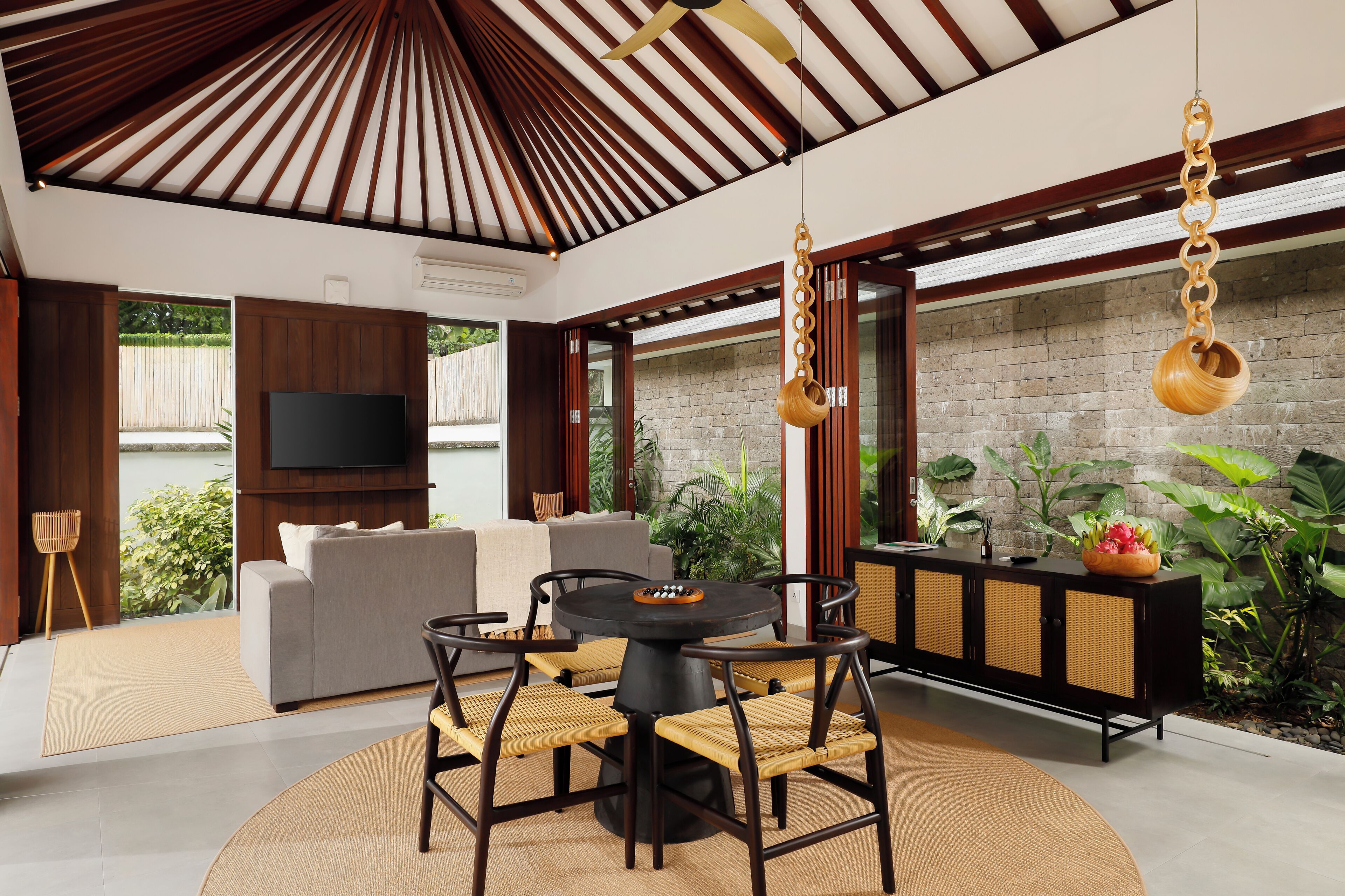 A modern living room with a round table, sofas, and a TV.
