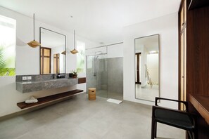 A modern bathroom with a glass shower, a large mirror, and a wooden bench. - Omekali Canggu by Nakula (Canggu)