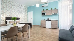 A modern apartment with a dining area, a kitchen with a built-in oven and microwave, and a living area with a sofa. - Italianway - Monza 39 (Milan)