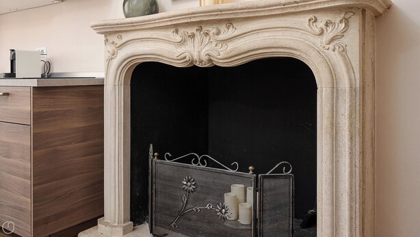 A fireplace with a decorative mantel, a dark firebox, and a metal screen. - Italianway - Monza 39 (Milan)