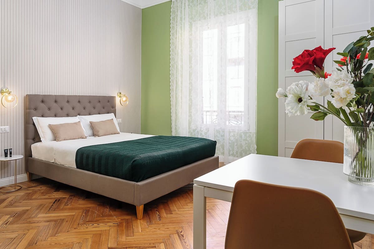A neatly arranged bedroom with a bed, bedside table, and a chair.
