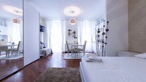 Una camera d'hotel moderna con un letto grande, una scrivania e un'area pranzo.