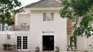 Een wit gebouw met een bord waarop staat 'ROZENBURG 1795'.