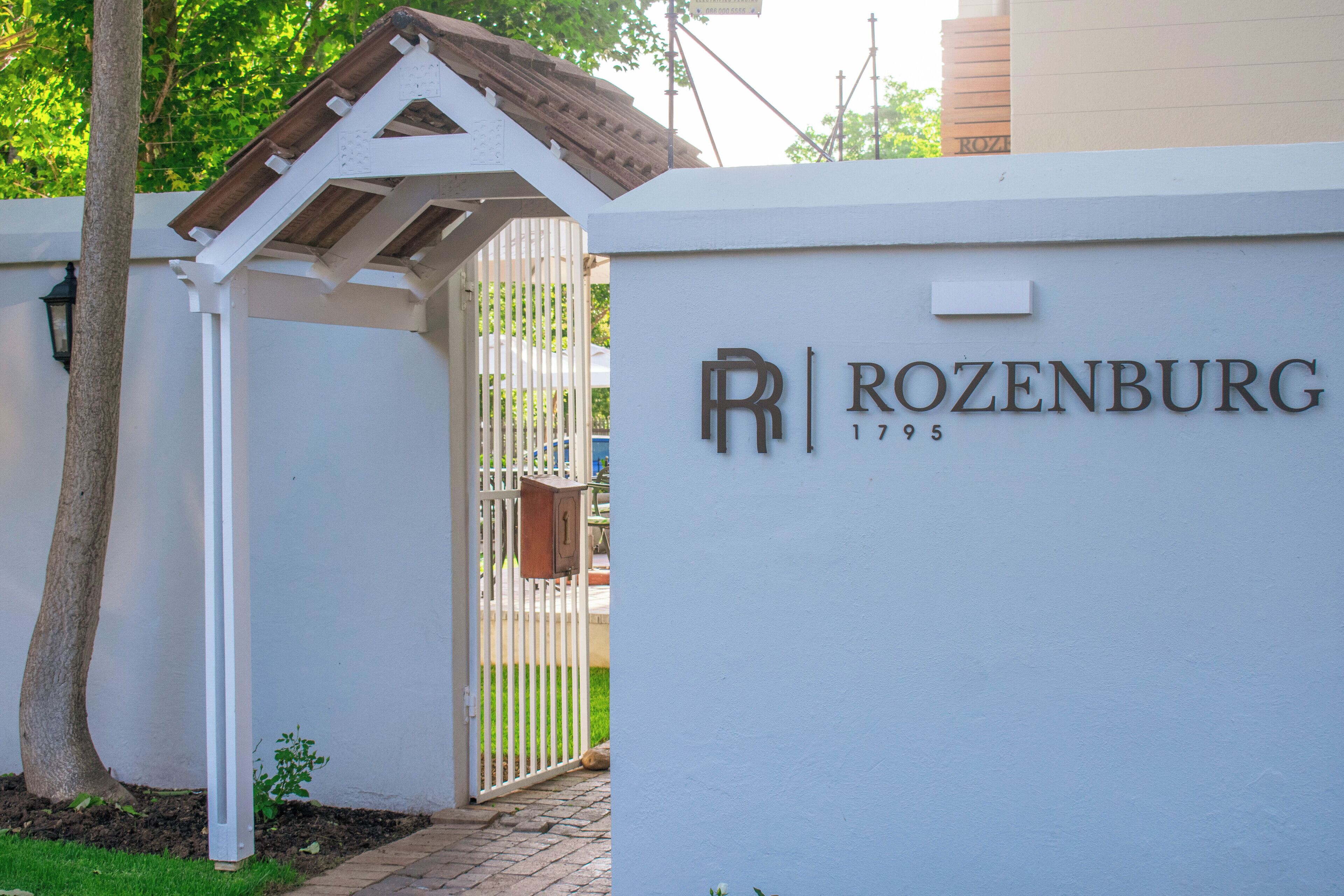 A white wall with the name "ROZENBURG 1795" and a gate.
