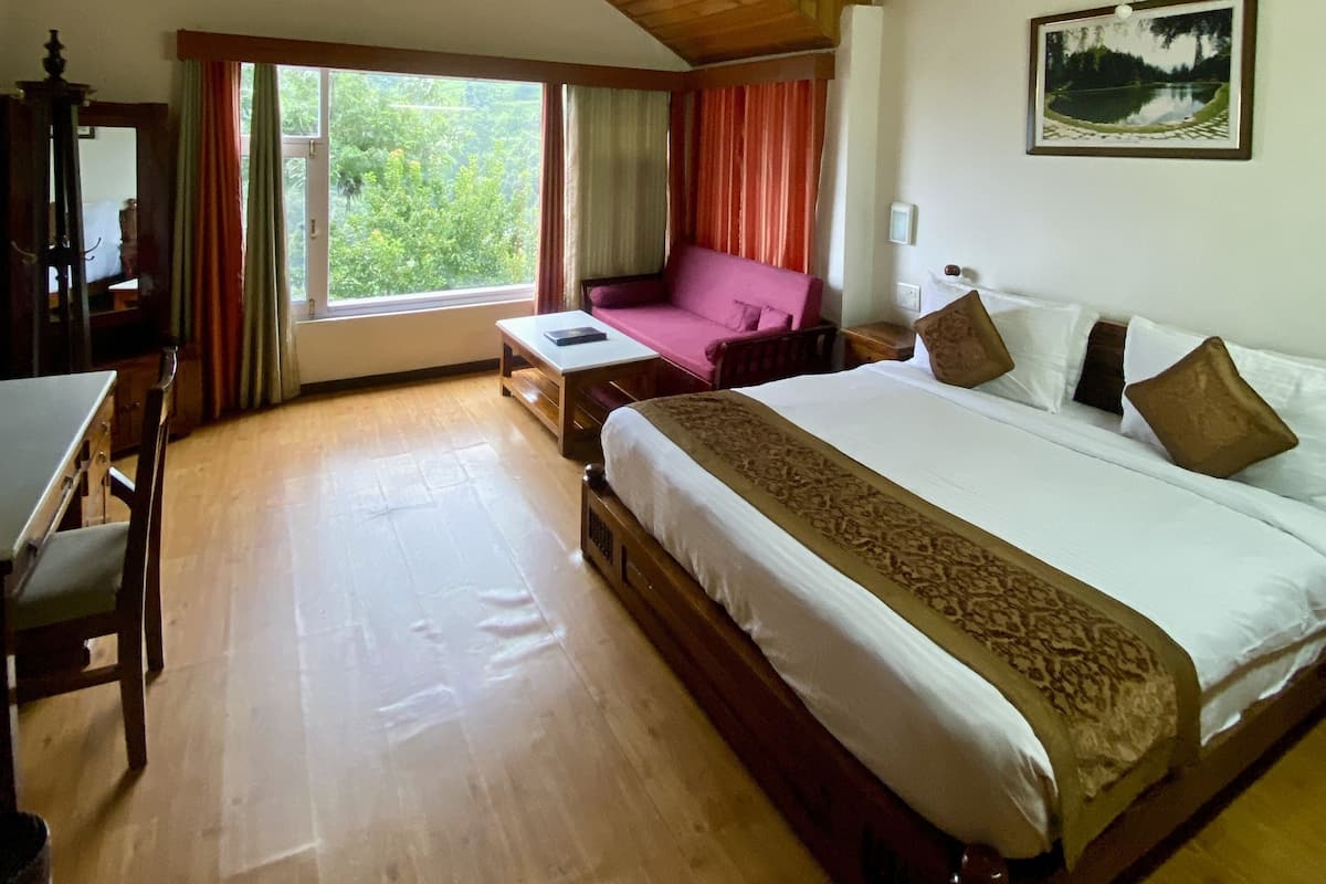Un dormitorio amplio con una cama grande, un ventilador de techo y una ventana con cortinas.