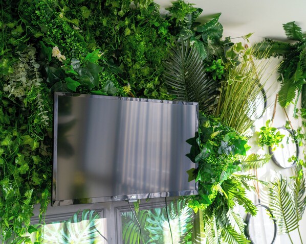 A wall with a large, metallic, rectangular object partially obscured by dense green foliage. - Leicester - Apartment - Sleeps 2 - 97ws (Leicester)