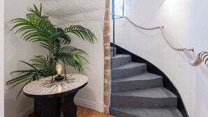 Een trap met een touwbalk, een ronde tafel met een wereldbol en een potplant.